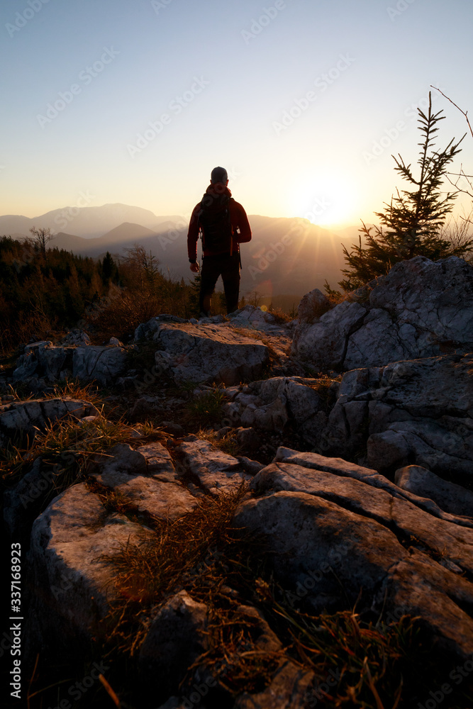 Man standing on Mountain Peak enjoying the Sunset Man standing on Mountain Peak enjoying the Sunset
