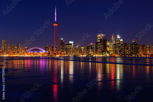 Toronto city skyline lights at night reflected on the frozen ice covered Lake Ontario © Reimar