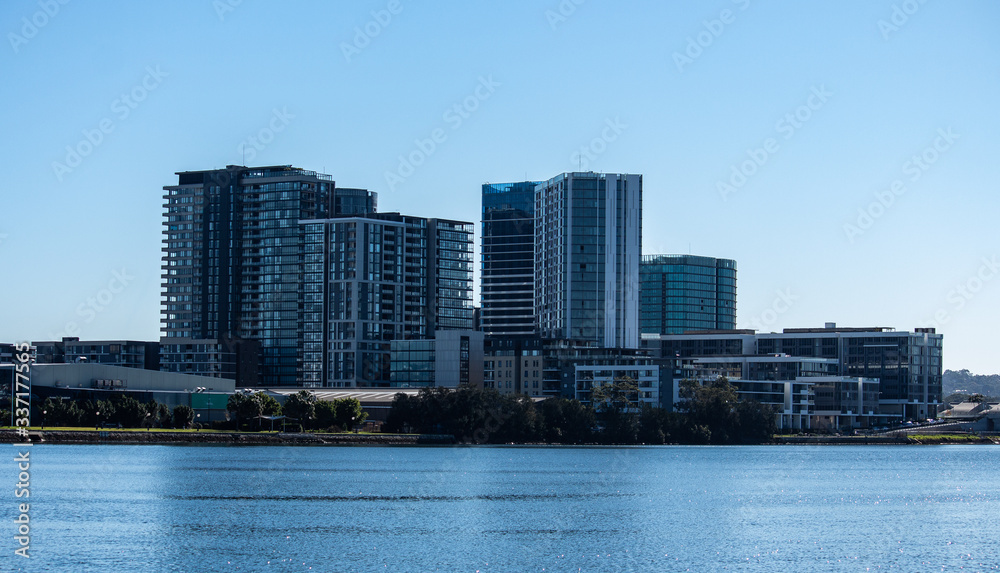 Urban high rise apartment condominiums community set on riverbank against blue sky