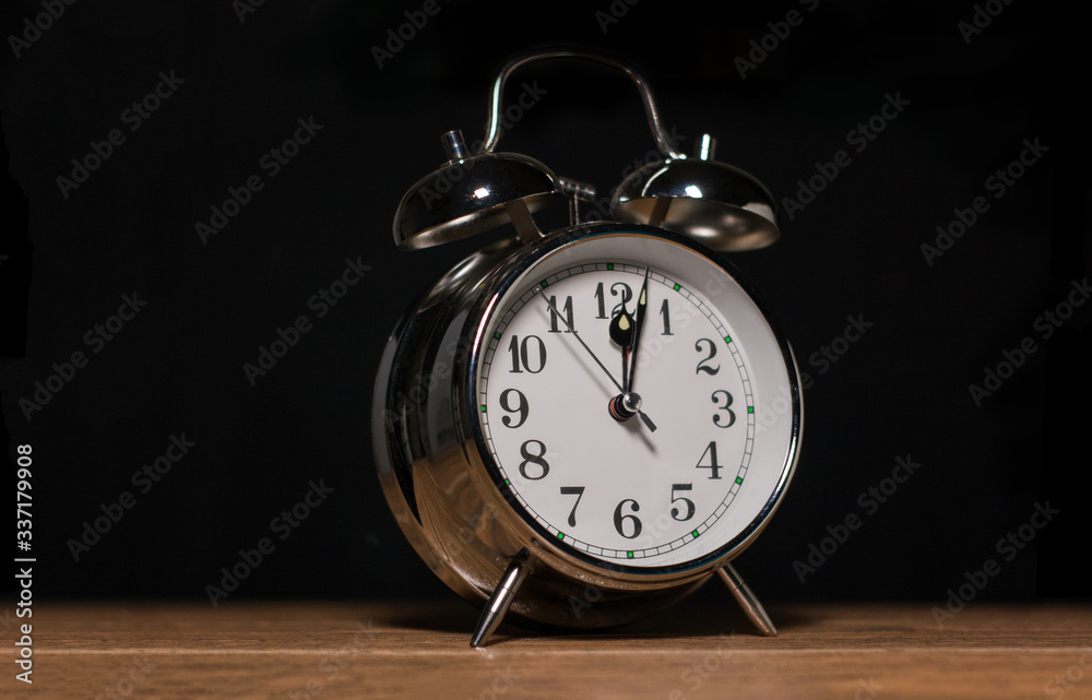 reloj metálico alarma marcando a las 12 en la noche sobre una mesa Stock  Photo | Adobe Stock