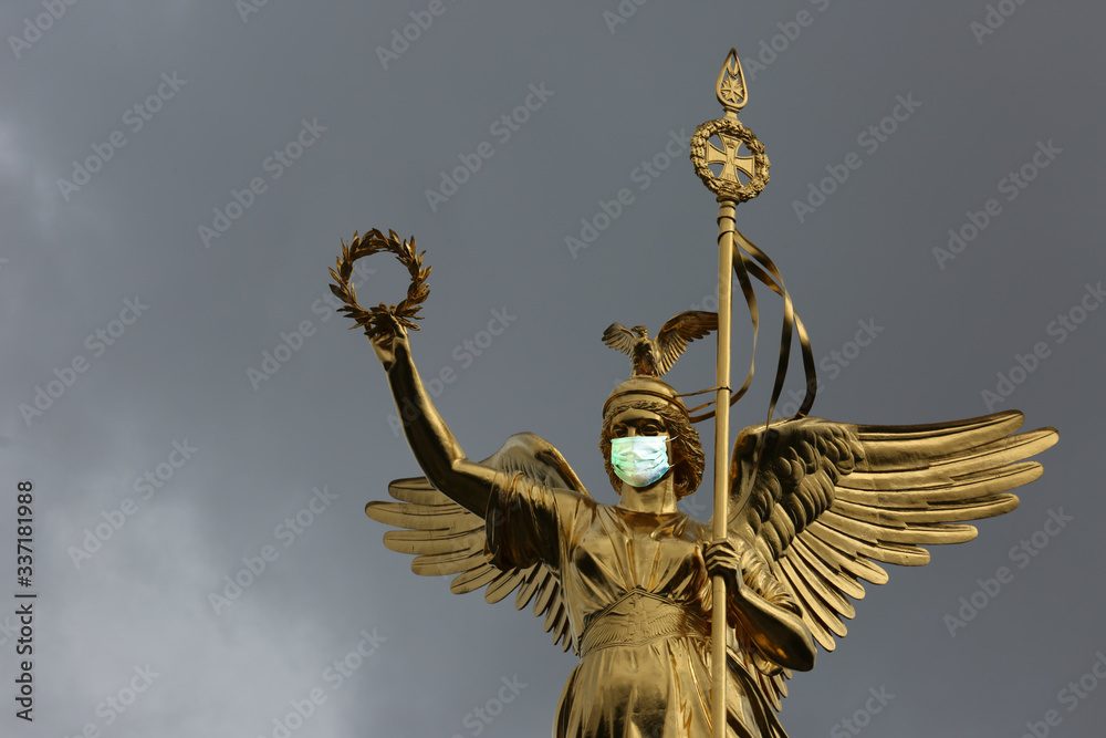 Obraz premium Coronavirus COVID-19 in Germany, medical mask on the Victory Column in Berlin.