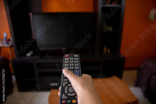 hand with remote control pointing at the television quarantined by the coronavirus in mexico