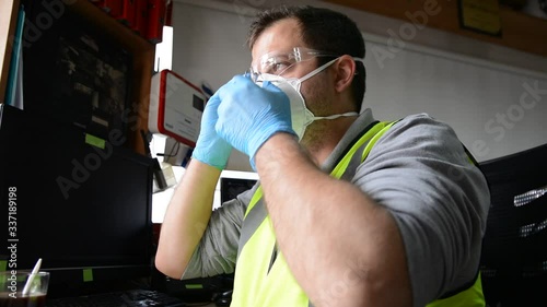 Man with medical face mask and gloves work at workplace