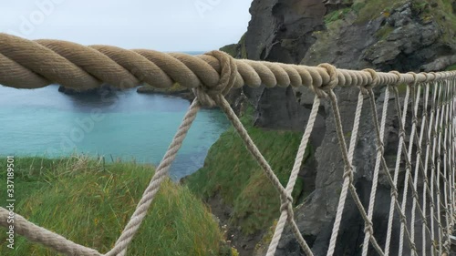 Close up of Rope Bridge with beautiful blue ocean and green grass