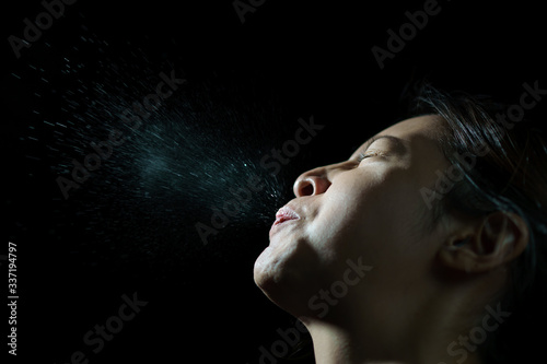 Woman coughing or sneezing. Concept of spread of the virus. Spray infection photo