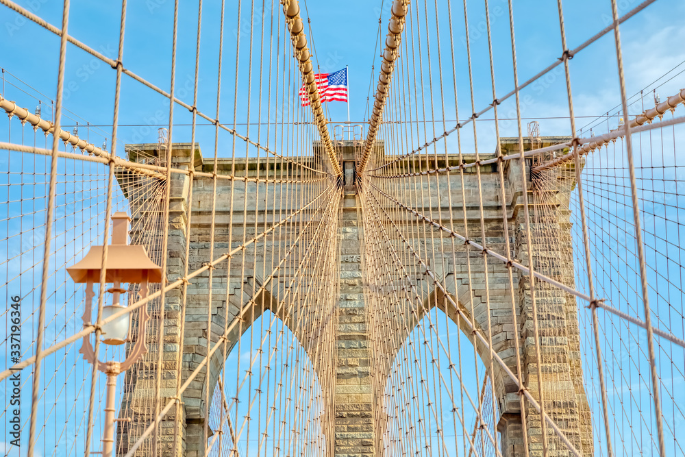 Obraz premium The United States flag on center of Brooklyn Bridge in New York