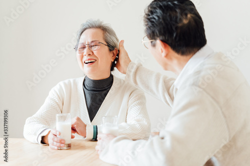 Asian aged couple drinking milk at home photo