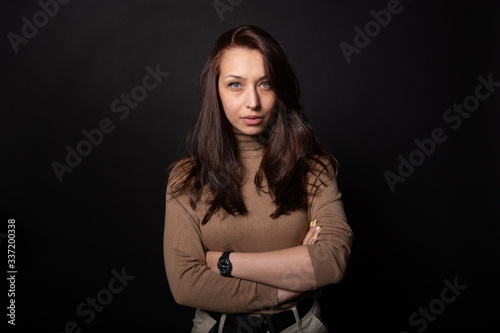 Beautiful woman with arm crossed and seriously looking at camera. Human portrait