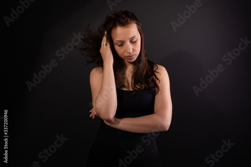 Woman feeling tired. Burnout, always-on lifestyle concept. Black background