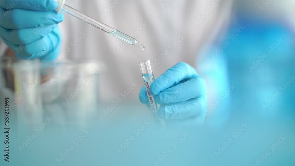 Scientist holding test tube with covid 19 or coronavirus vaccine label