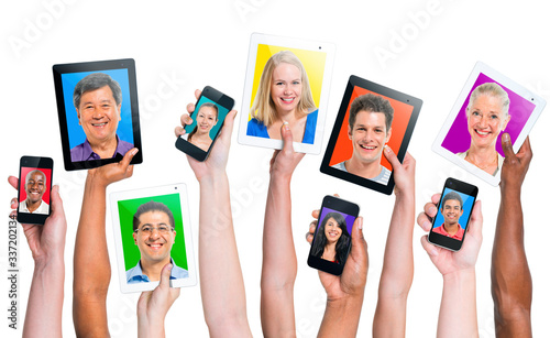 hand holding digital devices with diverse people faces on screen