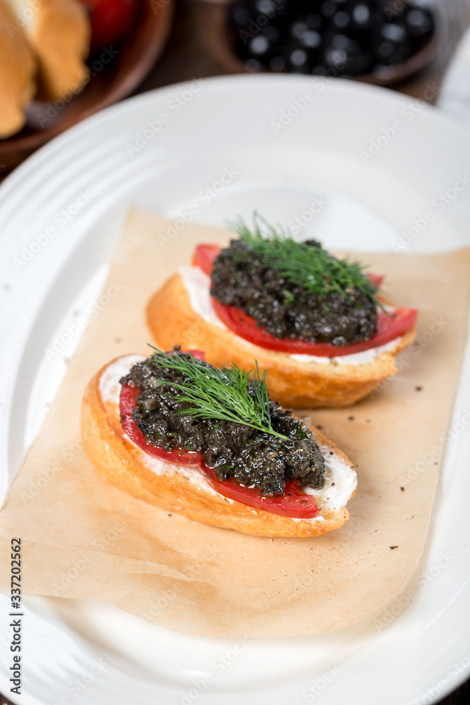 Bruschetta with olive paste on a white plate Bruschetta with olive paste on a white plate
