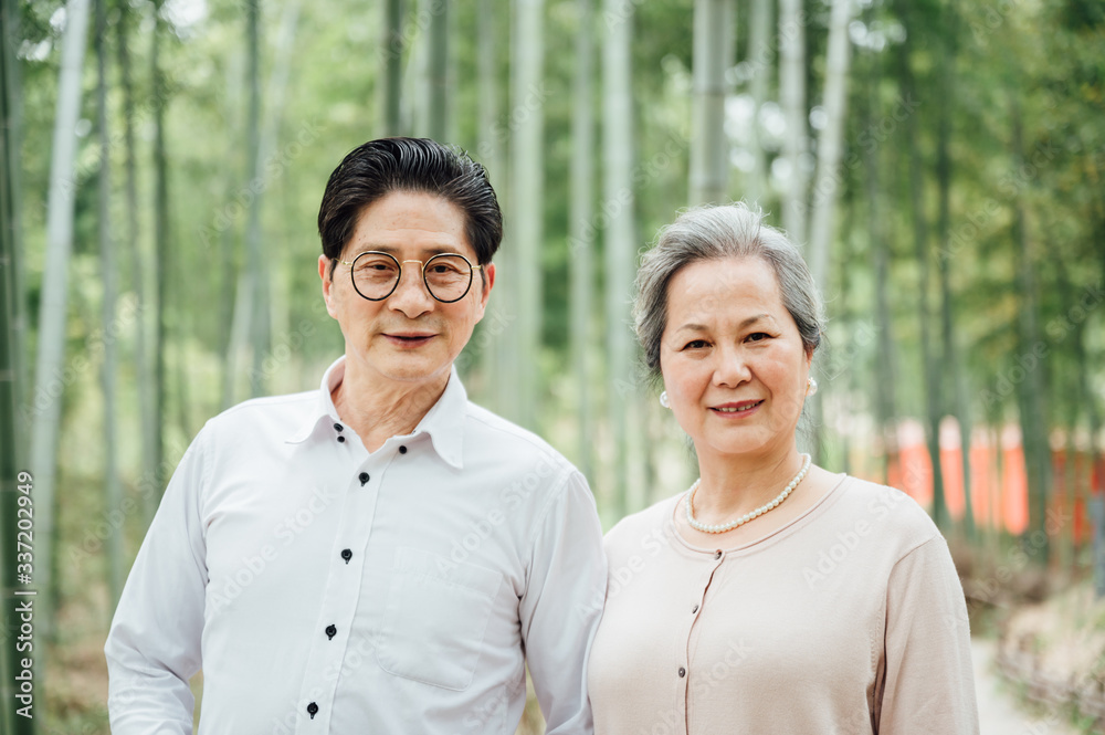 Asian aged couple walking in the bamboo forest Asian aged couple walking in the bamboo forest