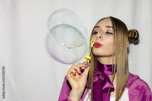 Cute girl with pigtails blowing soap bubbles