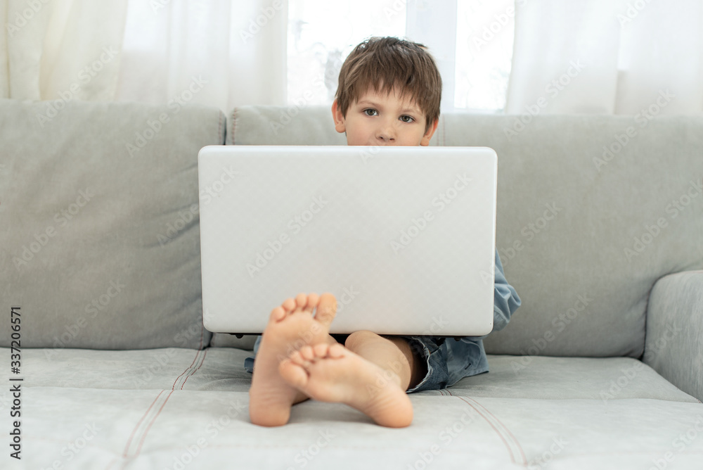 Kids and gadgets. Distance learning during isolation during quarantine in coronavirus. Boy and laptop at home. Lifestyle Kids and gadgets. Distance learning during isolation during quarantine in coronavirus. Boy and laptop at home. Lifestyle