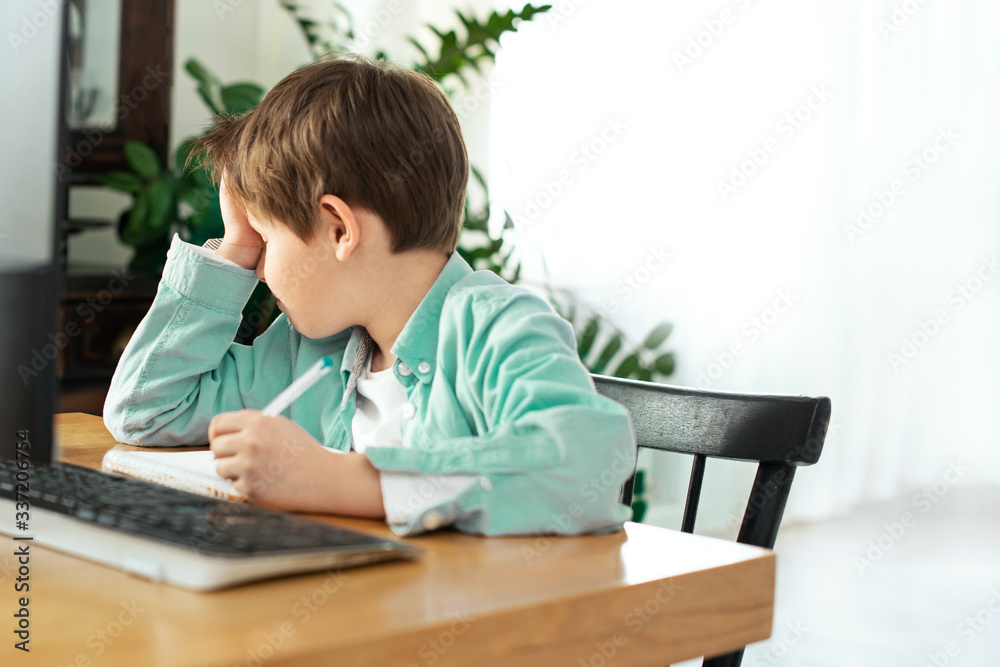 Kids and gadgets. Distance learning during isolation during quarantine in coronavirus. Boy and laptop at home. Lifestyle. Lockdown and Social Distancing Kids and gadgets. Distance learning during isolation during quarantine in coronavirus. Boy and laptop at home. Lifestyle. Lockdown and Social Distancing