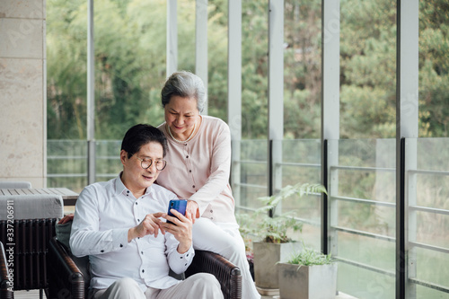 Asian aged couple using smartphone photo
