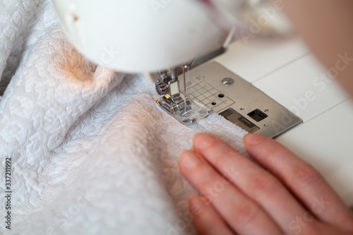 Seamstress hand guides seam on modern sewing machine