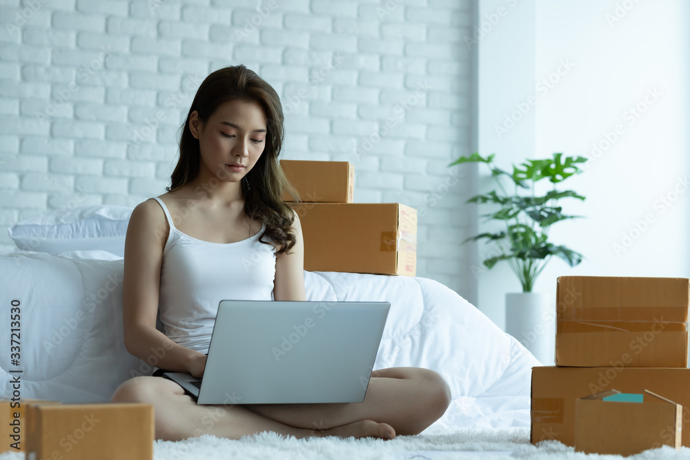 Asian women working with laptop for Online shopping at home with box for packaging in home,Own Small Business Start up for Online shopping.Small business concept. Asian women working with laptop for Online shopping at home with box for packaging in home,Own Small Business Start up for Online shopping.Small business concept.