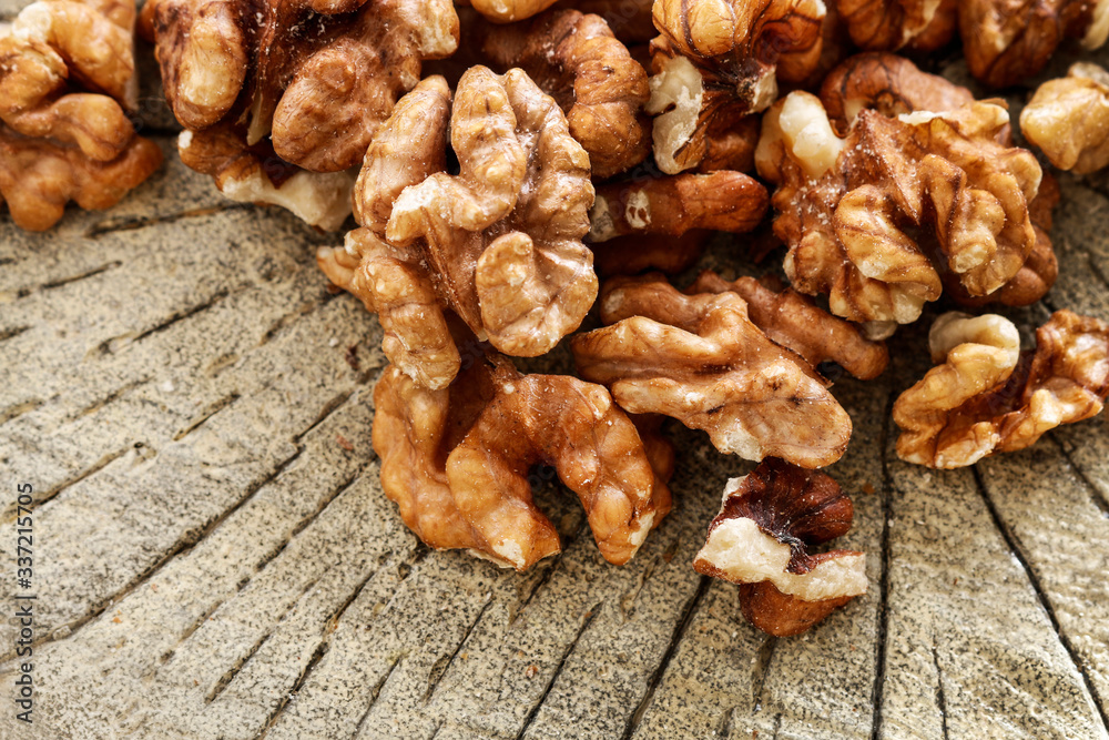 Fototapeta premium Walnuts on brown wooden background.