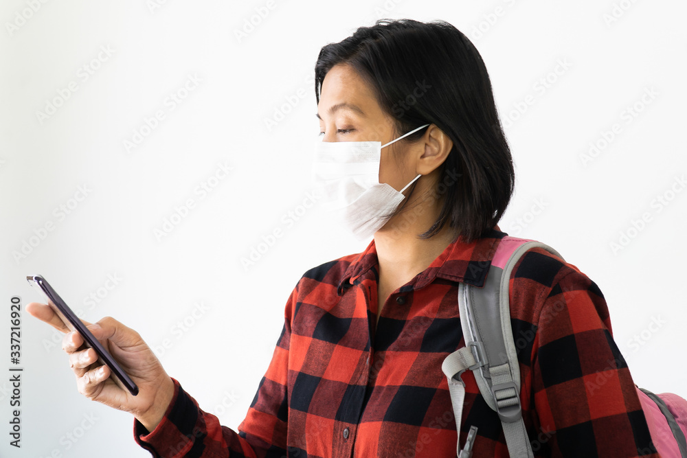 Traveller woman under surgical face mask covering mouth and nose. Awareness and Watch out Corona Virus or COVID-19 concept. Traveller woman under surgical face mask covering mouth and nose. Awareness and Watch out Corona Virus or COVID-19 concept.