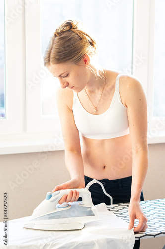 young woman ironing clothes