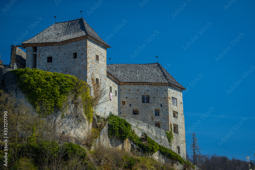 View of partially restored medieval castle of Kostel in the village of Kostel, close to Kolpa, Slovenia, on a sunny day with clear blue sky. Beautiful castle panorama.