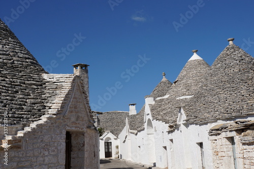 Small street detail of white round houses with specific architecture and stone roof from unesco world heritage Trulli of Alberobello in Italy