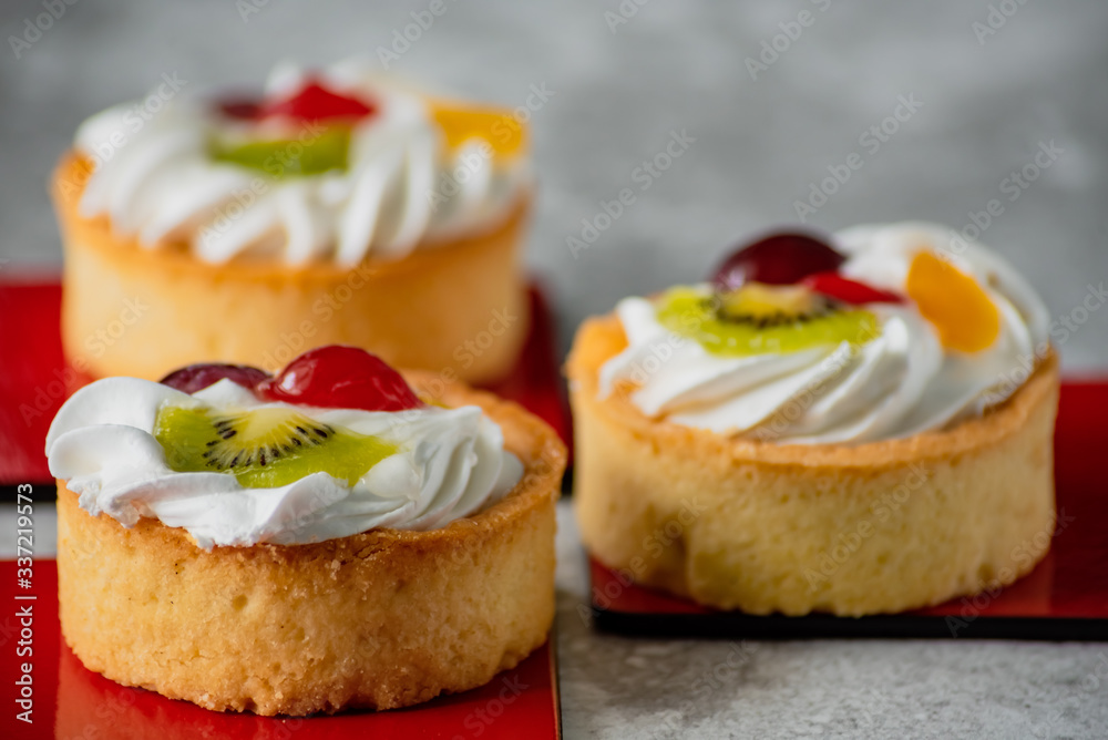 Cakes with whipped cream and slices of fruit Cakes with whipped cream and slices of fruit