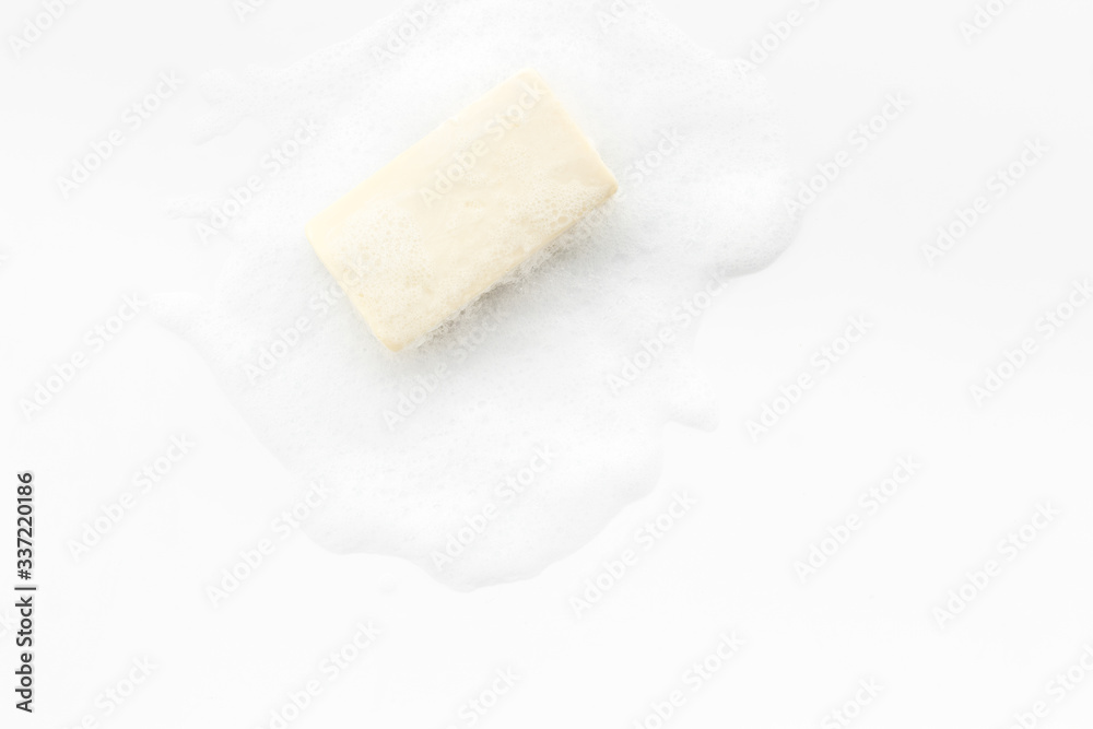 Soap bar with foam on white background top-down copy space