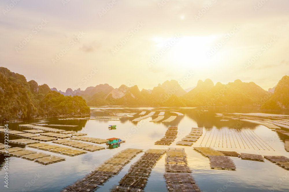 Fototapeta premium Aerial view fishing village and rock island, Bai Tu Long Bay, Vietnam, Southeast Asia. UNESCO World Heritage Site. Junk boat cruise to Ha Long Bay. Popular landmark, famous destination of Vietnam