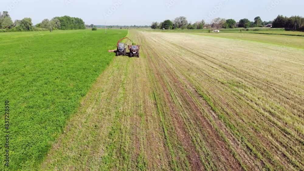 Two Old Tractors With Mower And Trailer Mow Clover In The Field
