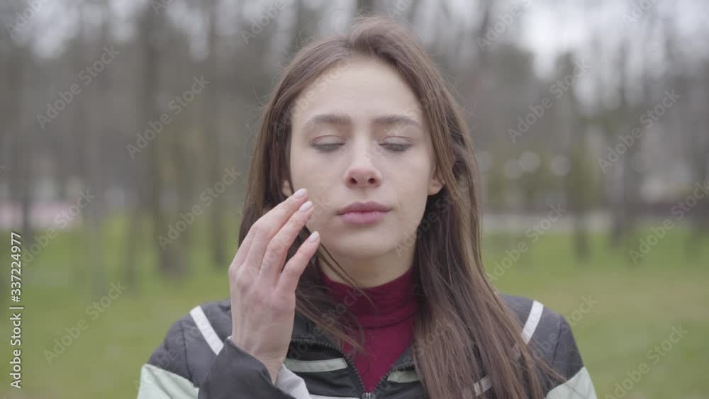 Portrait of brunette girl taking off protective mask and touching face. Young Caucasian woman ignoring coronavirus quarantine. Covid-19 pandemic, infectious disease outbreak, virus spreading. Portrait of brunette girl taking off protective mask and touching face. Young Caucasian woman ignoring coronavirus quarantine. Covid-19 pandemic, infectious disease outbreak, virus spreading.