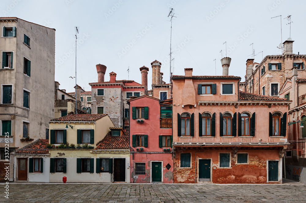 Venice, Italy - February 19, 2020: Colorful houses in the old medieval street in Venice, Veneto, Italy
