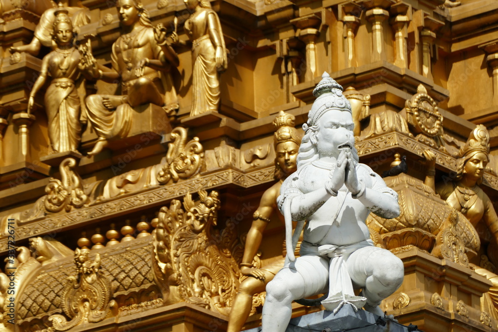Golden indian temple with white statue on the front 
