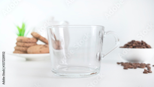 Glass cup with granules of instant coffee over on white background. Close up.