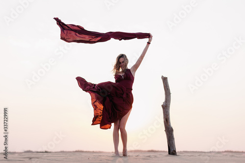 wind inflates a girl's dress in the desert