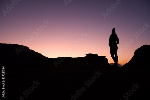 Woman watching sunrise in Wadi Rum desert, Jordan