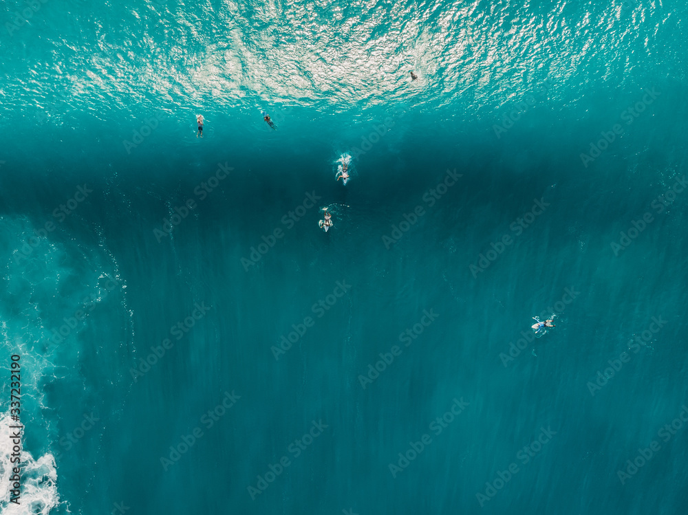 Aerial view of surfers in ocean. Top view. Surfing in tropical sea