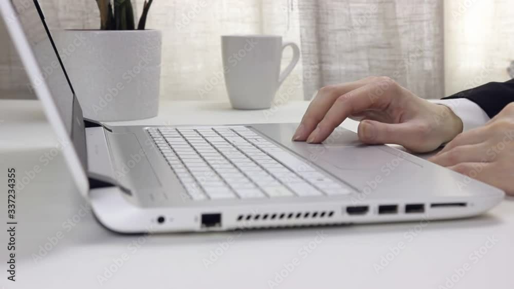 A young woman in a shirt taps his fingers on his laptop, nervous. Remote work in the home office. Waiting, boredom. A young woman in a shirt taps his fingers on his laptop, nervous. Remote work in the home office. Waiting, boredom.