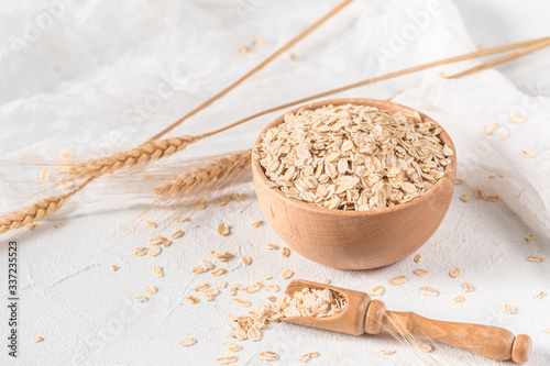 Raw oatmeal flakes on light background