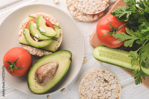 Top view healthy breakfast rice cake with avocado and tomato with cucumber