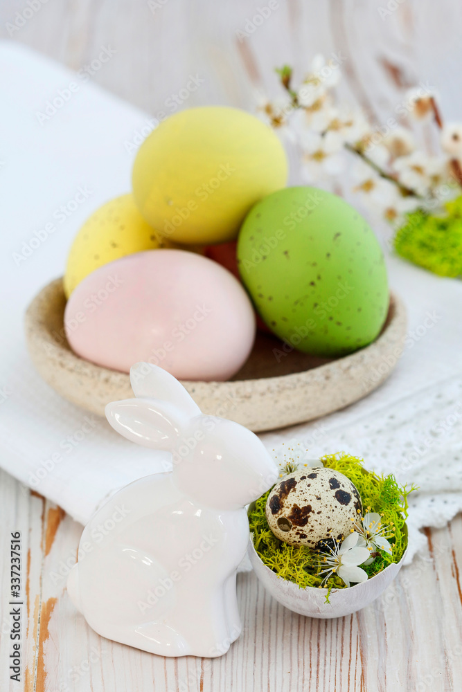 Easter table decoration with colorful eggs and ceramic  rabit figurine.