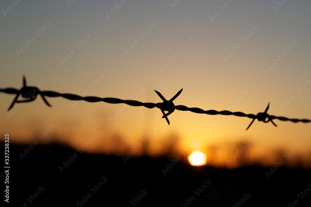 Close-up Of Silhouette Barbed Wire Against Sky At Sunset - obrazy, fototapety, plakaty 
