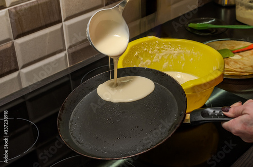 Pancakes are fried in a pan on an induction stove