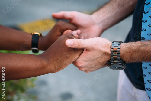 Mixed race couple holds each others hands and sharing the feelings of happiness, serenity, joy, friendship and love. Time spent together. Different cultures, races, nations unites