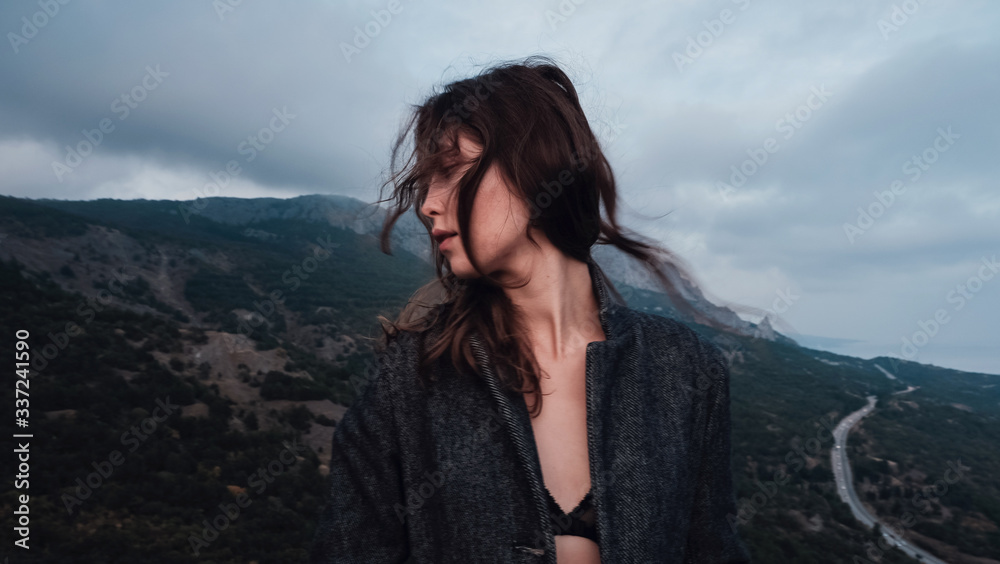 Asian woman in a gray coat enjoying the view in the mountains