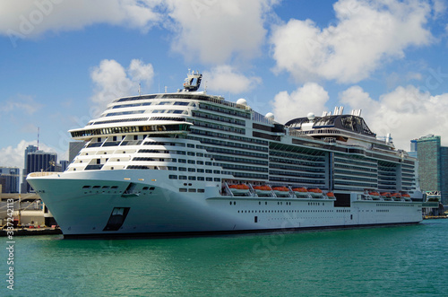 Big modern MSC Cruises cruiseship or cruise ship liner Meraviglia in Port of Miami, Florida with downtown skyline and skyscrapers in background waiting for passengers for Caribbean cruising holiday photo