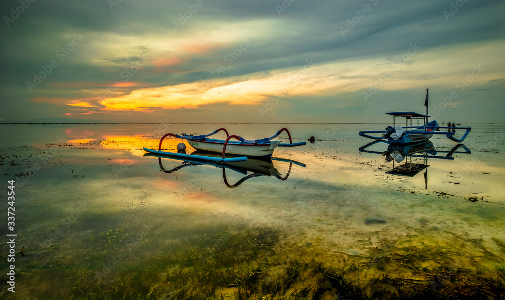 Landscape. Fisherman boats jukung. Traditional fishing boats at the beach during sunrise. Sanur beach, Bali, Indonesia.