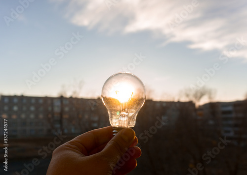 incandescent light bulb on the background of the sun 